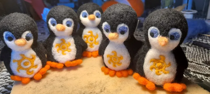 Fünf kleine Pinguine mit leuchtend gelben Motiven.