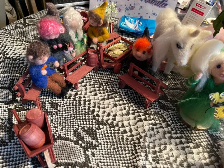 Eine kleine Welt mit Figuren, Bänken und Wagen.